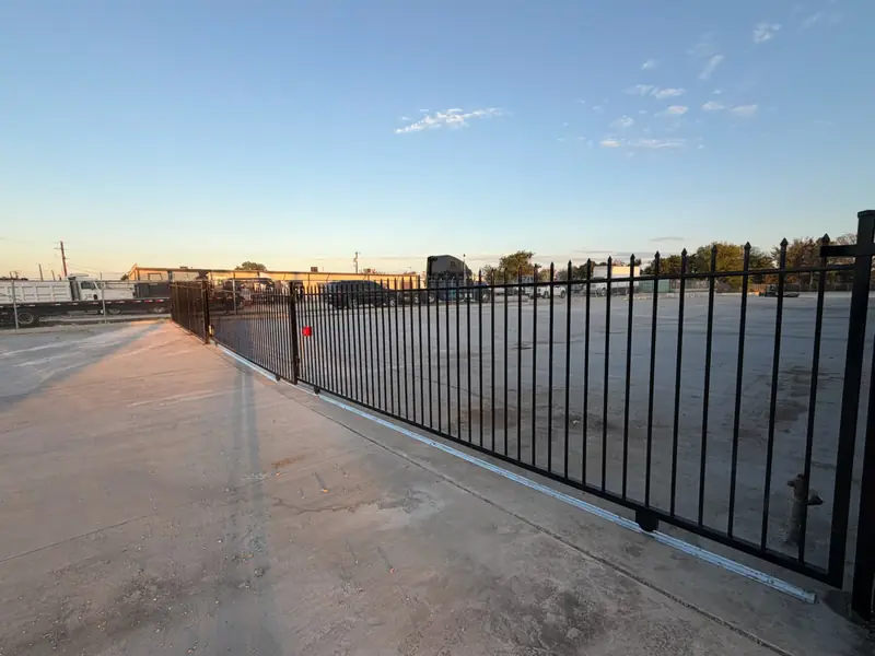 Iron sliding gate securing a commercial parking lot in DFW
